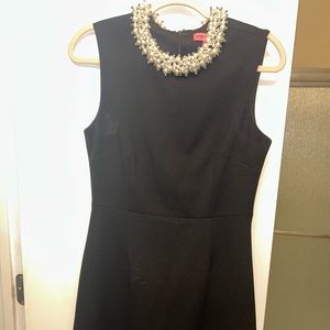 Black sheath dress with pearl neckline.